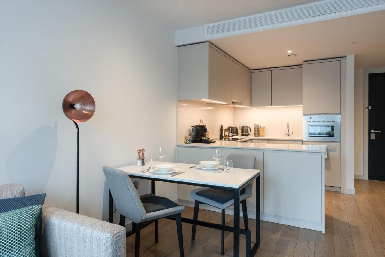 Citysuites Aparthotel Manchester Esterno foto The photo shows a modern and stylish kitchen and dining area. The kitchen features sleek cabinets with a subtle color palette and built-in appliances, including an oven and possibly a stovetop. A countertop is visible, with kitchen utensils and small
