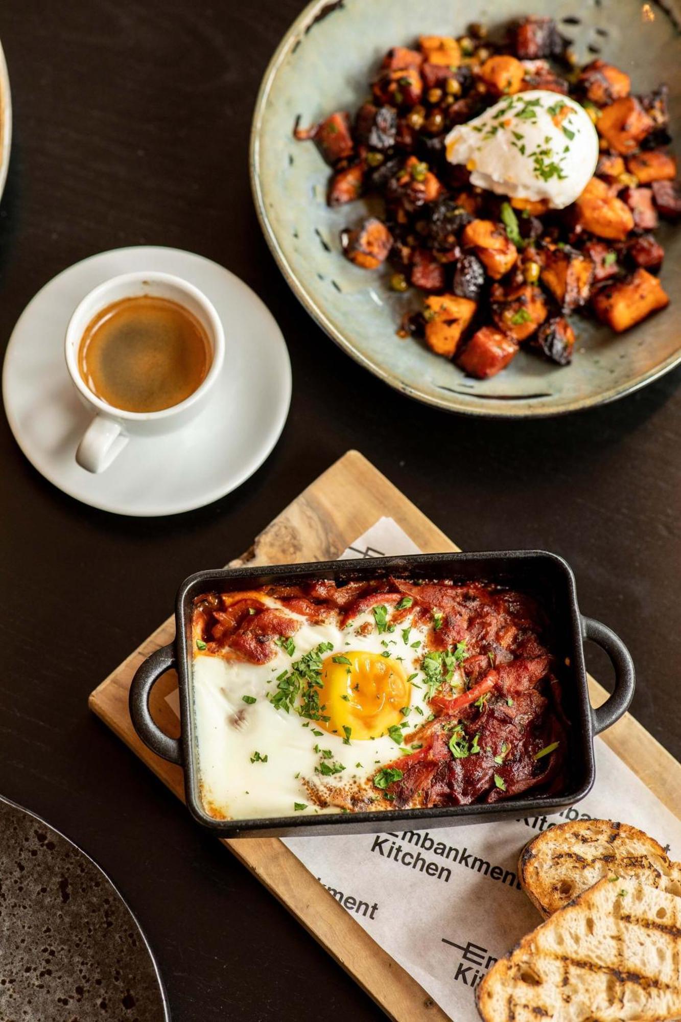 Citysuites Aparthotel Manchester Esterno foto The photo features a plate of food that includes a baked dish with a sunny-side-up egg on top, surrounded by a rich, tomato-based sauce, and garnished with chopped herbs. Next to it, there are roasted or grilled vegetables, likely sweet potatoes or s