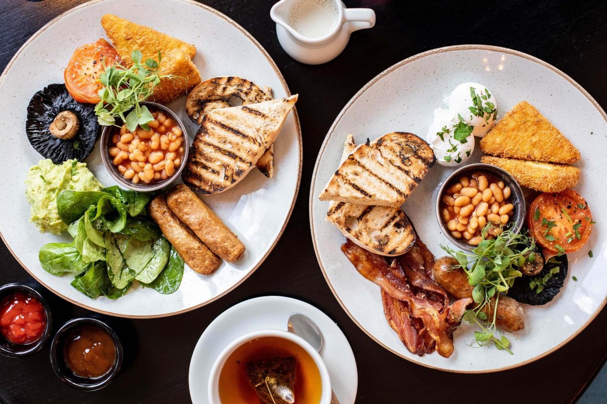 Citysuites Aparthotel Manchester Esterno foto The photo displays two plates of breakfast food. Each plate has a variety of items, including:

- Grilled slices of bread
- Beans served in a small bowl
- Grilled sausages
- Sliced tomatoes
- Sautéed greens or salad
- A portion of golden-brown fried 